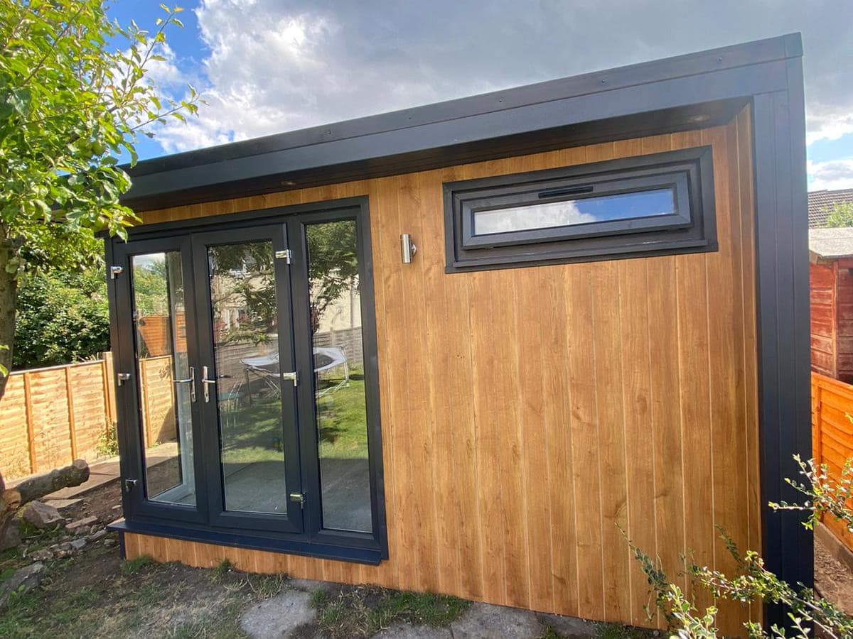 The same garden room finished in cedar cladding with an anthracite roof trim and window